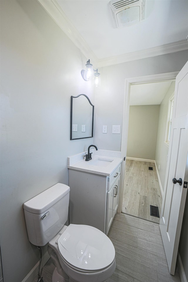 bathroom with ornamental molding, vanity, and toilet