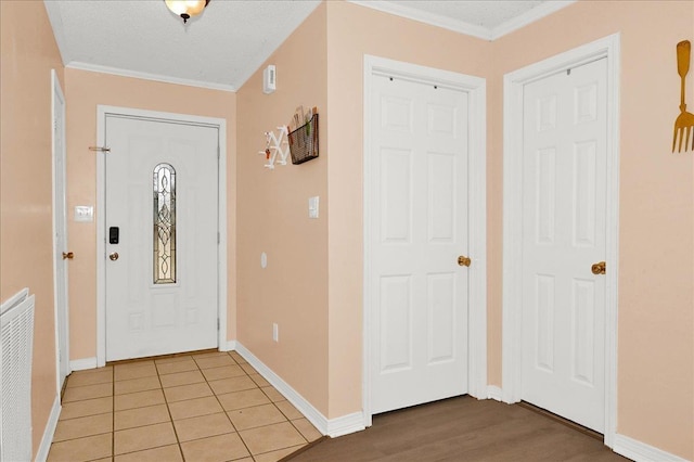  - foyer entrance featuring crown molding and baseboards