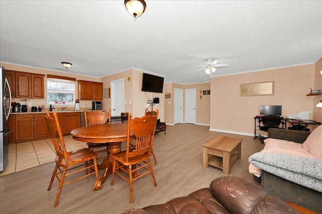  - dining space featuring crown molding, a ceiling fan, light wood-type flooring, and a textured ceiling