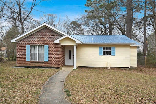  - ranch-style home featuring a metal roof, a front lawn, and brick siding