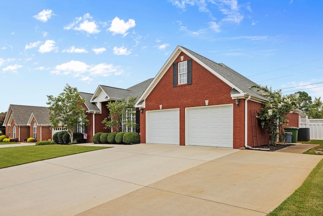 view of front of property featuring cooling unit, a garage, and a front yard