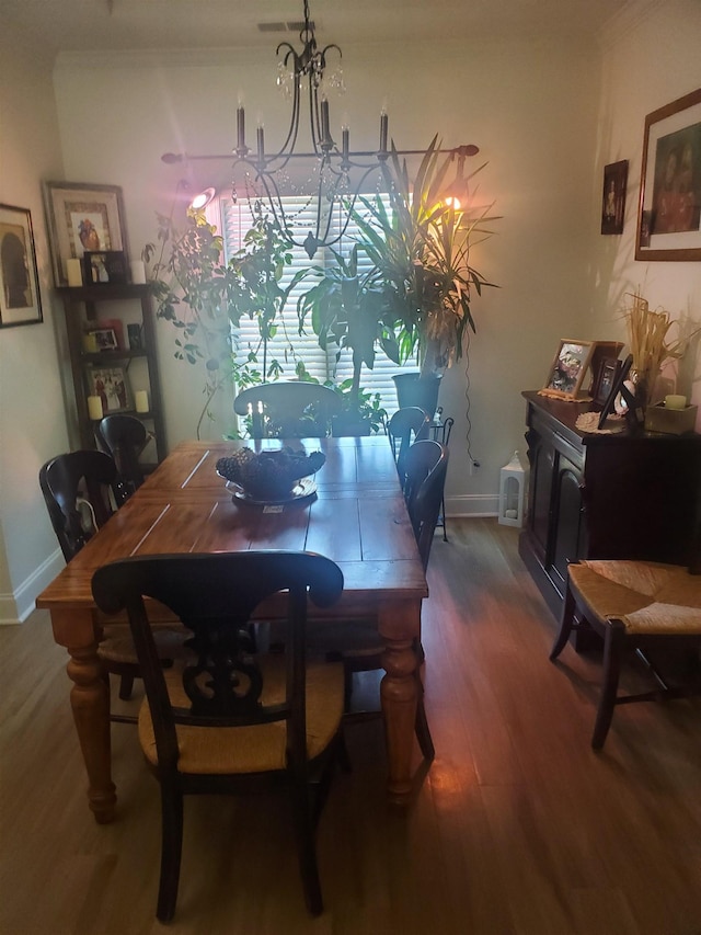 dining room featuring crown molding, a chandelier, and dark hardwood / wood-style floors