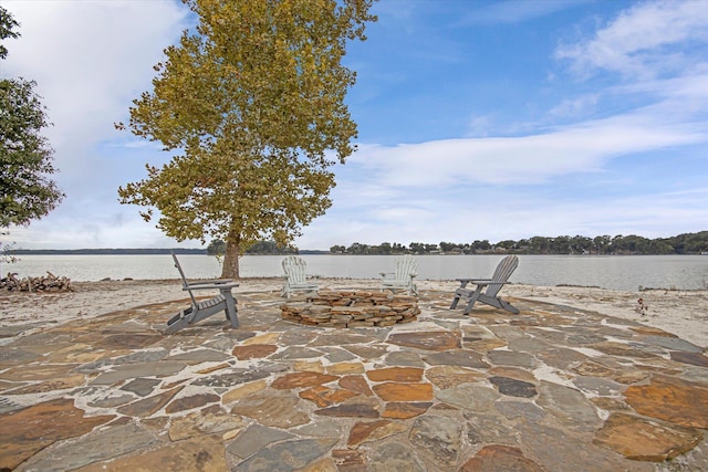  - view of patio / terrace with an outdoor fire pit and a water view
