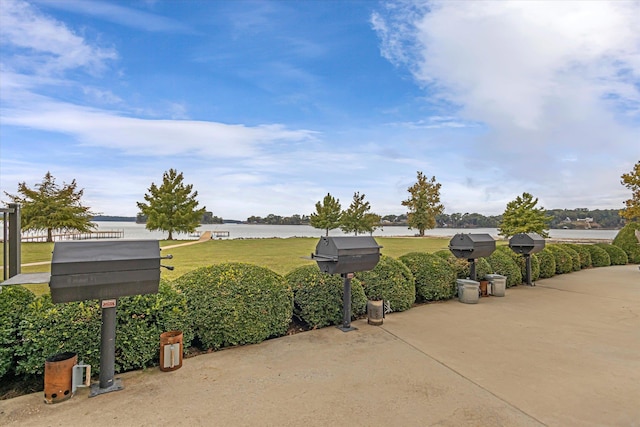  - view of community with a water view, a yard, and a patio