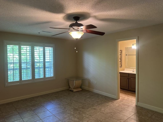  - unfurnished room with ceiling fan, a textured ceiling, and baseboards