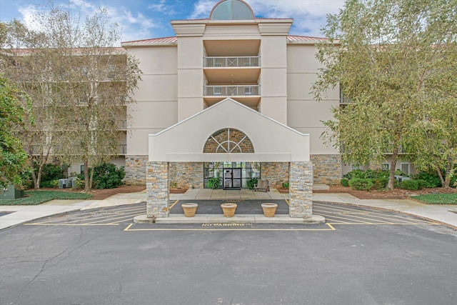 - view of building exterior featuring uncovered parking