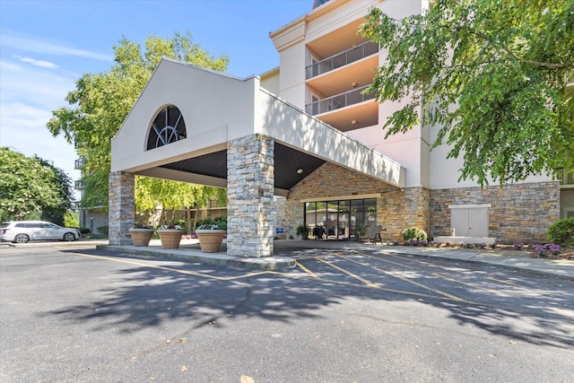  - view of building exterior featuring uncovered parking