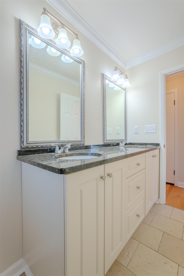bathroom with a sink, double vanity, and crown molding