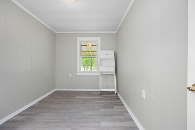 unfurnished room with a textured ceiling, crown molding, and light hardwood / wood-style flooring