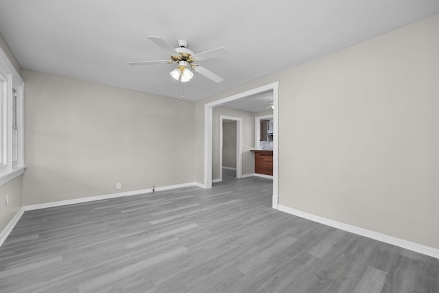 empty room with ceiling fan and light wood-type flooring