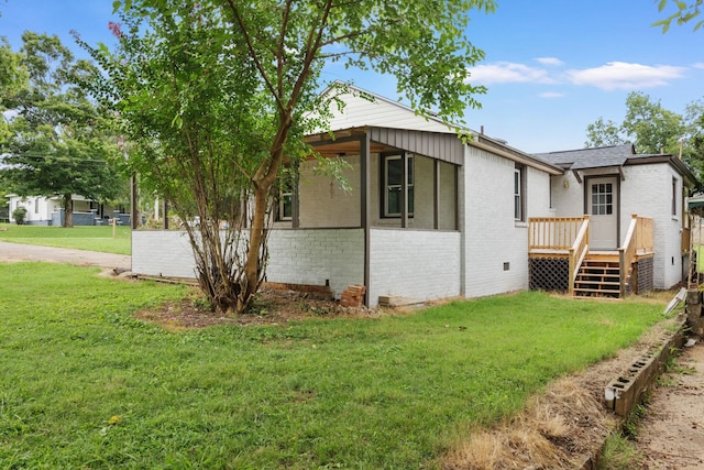 view of side of property featuring a wooden deck and a lawn