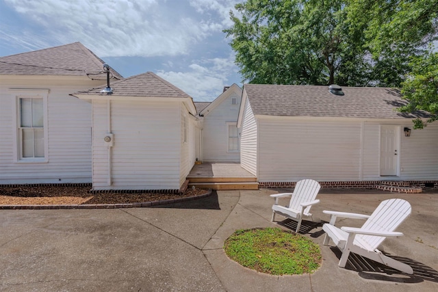  - back of house featuring a patio, a shingled roof, and a wooden deck