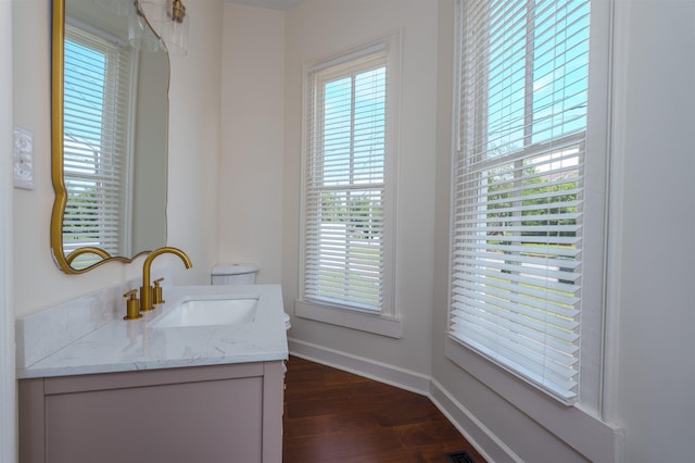  - bathroom featuring toilet, wood finished floors, vanity, and baseboards