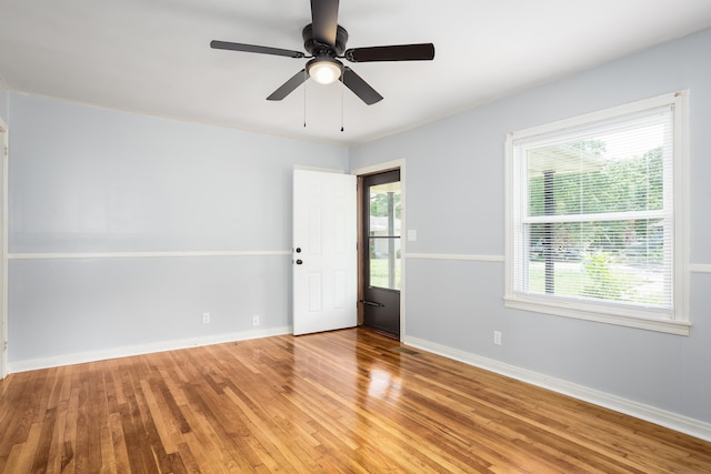 spare room featuring baseboards, ceiling fan, and wood finished floors