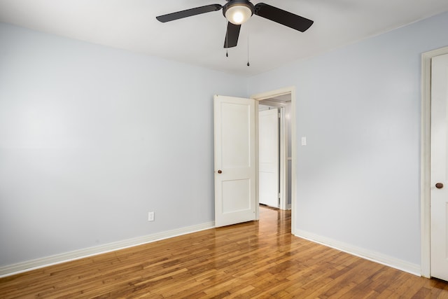 spare room featuring light wood-type flooring, baseboards, and a ceiling fan