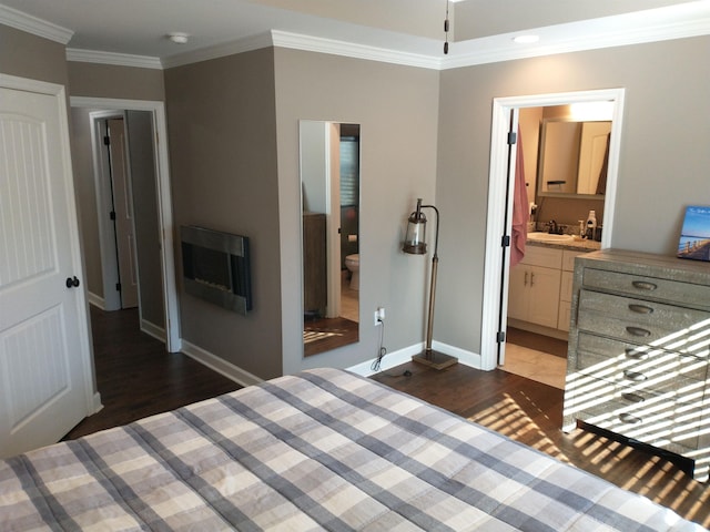 unfurnished bedroom with ornamental molding, sink, ensuite bathroom, and dark hardwood / wood-style flooring