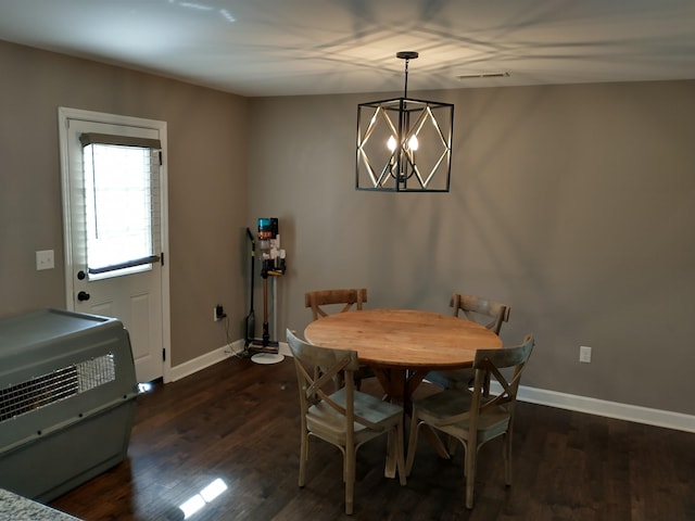 dining area with an inviting chandelier, heating unit, and dark hardwood / wood-style flooring