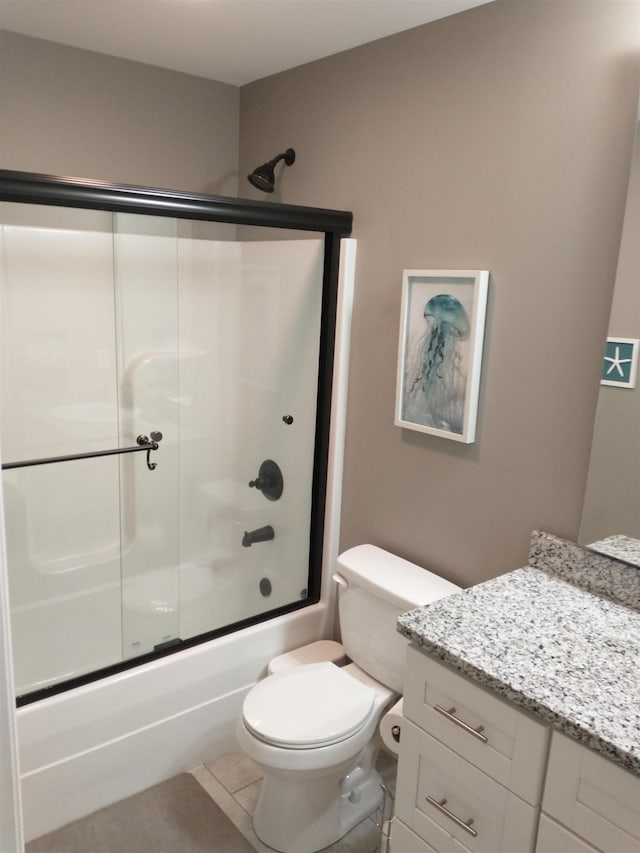 full bathroom featuring tile patterned flooring, bath / shower combo with glass door, vanity, and toilet