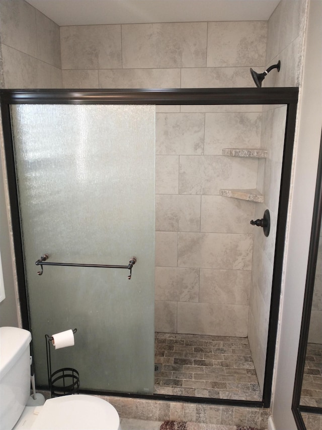 bathroom with an enclosed shower and toilet