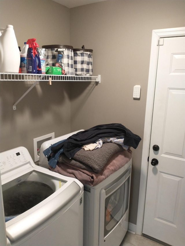 laundry room with light tile patterned floors and washing machine and clothes dryer