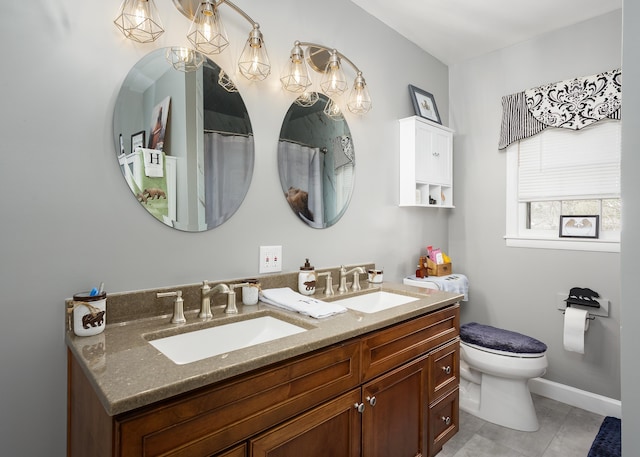  - bathroom with baseboards, double vanity, a sink, and toilet