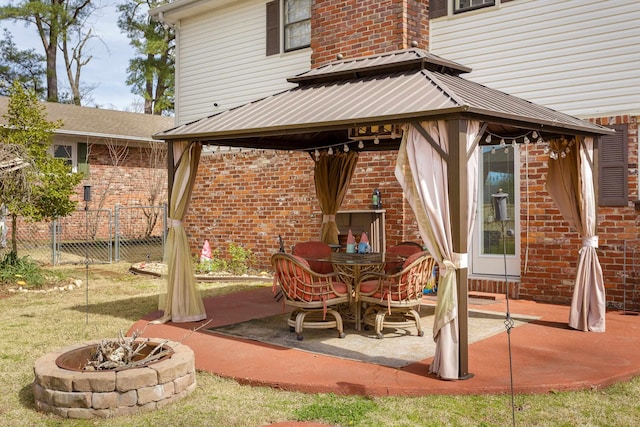 - view of patio / terrace featuring a fire pit, a gazebo, and fence
