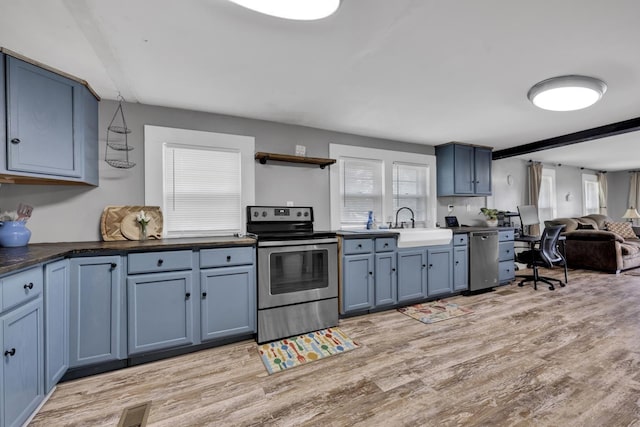  - kitchen with stainless steel appliances, blue cabinetry, and plenty of natural light