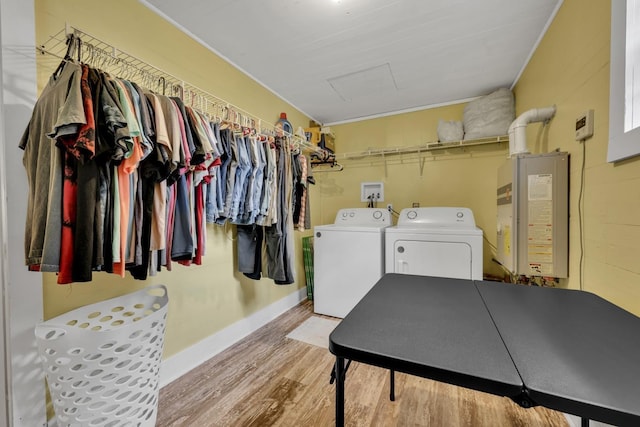  - laundry area with washing machine and clothes dryer, wood finished floors, attic access, ornamental molding, and water heater