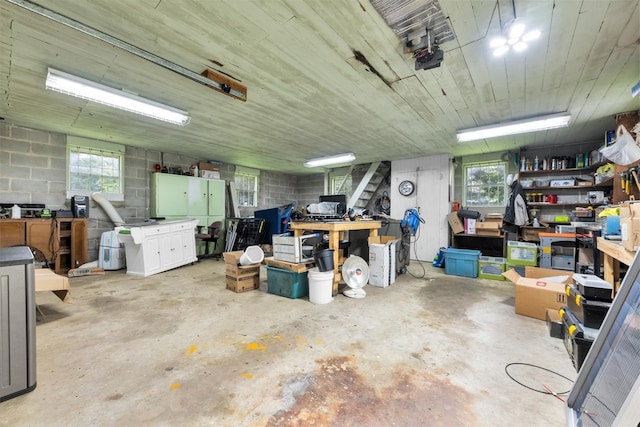 - garage featuring a workshop area, concrete block wall, and a garage door opener