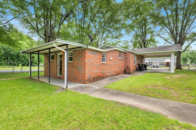  - view of side of property featuring an attached carport, a patio, and brick siding