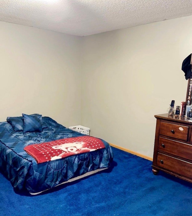 bedroom featuring dark carpet and a textured ceiling