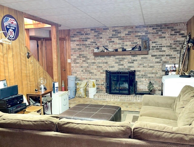 living room with wooden walls and a brick fireplace