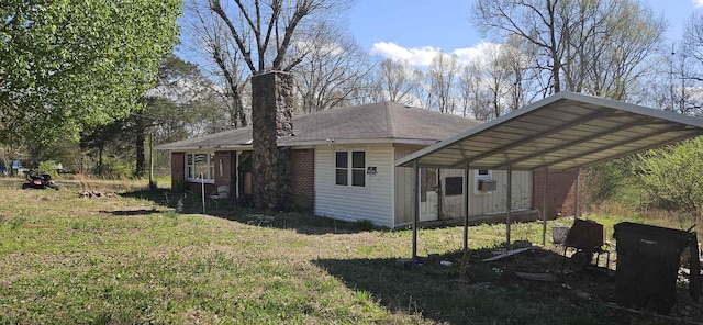 rear view of property with a carport, cooling unit, and a lawn