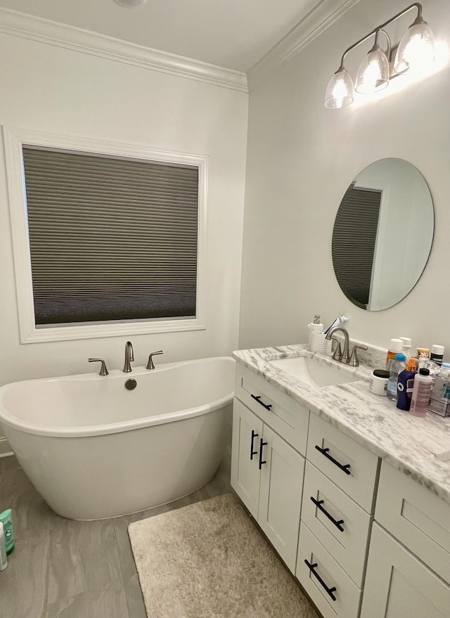 bathroom featuring a bathing tub, vanity, and ornamental molding