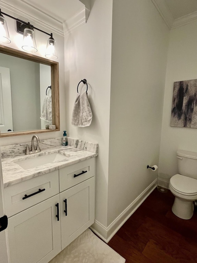 bathroom with vanity, hardwood / wood-style flooring, toilet, and ornamental molding