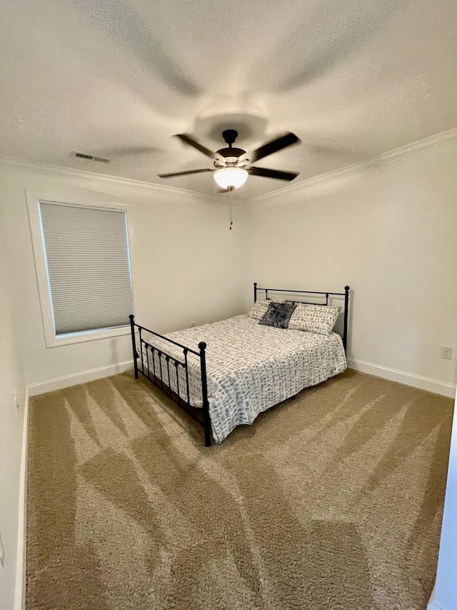 carpeted bedroom with a textured ceiling, ceiling fan, and crown molding