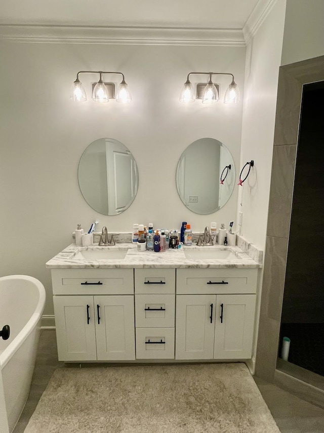 bathroom with tile patterned floors, vanity, ornamental molding, and a tub to relax in