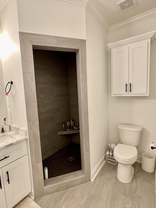 bathroom with tiled shower, vanity, toilet, and crown molding