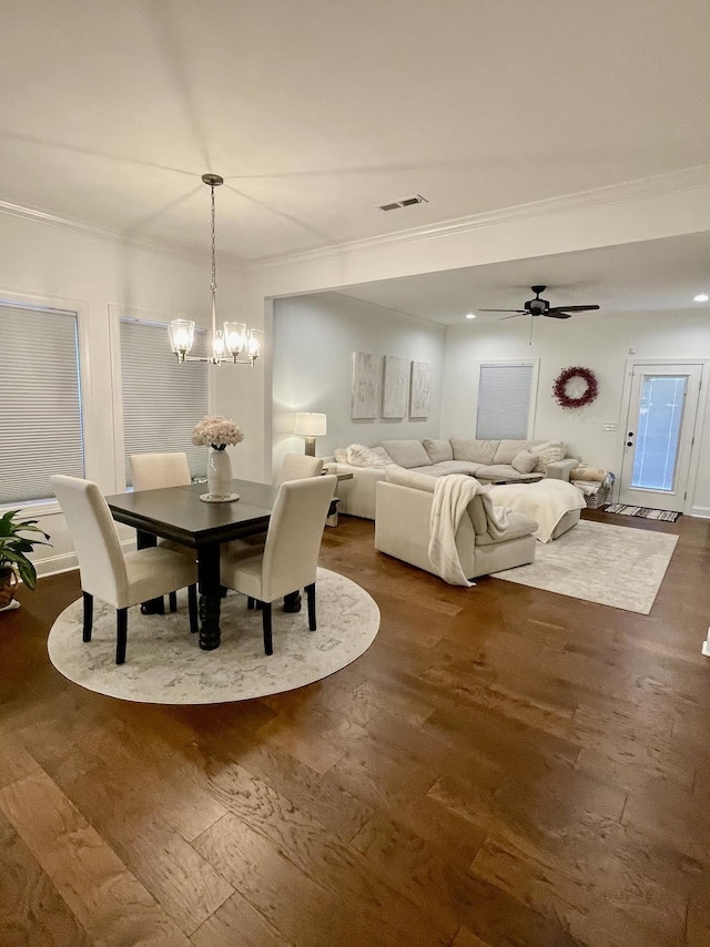 dining space with ceiling fan with notable chandelier, dark hardwood / wood-style flooring, and ornamental molding