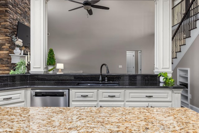 kitchen with a sink, dark stone counters, ceiling fan, and dishwasher