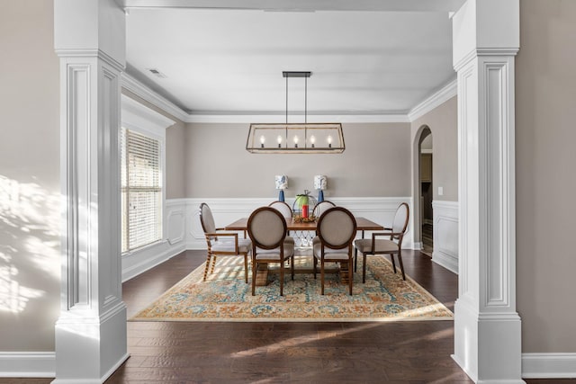 dining space featuring arched walkways, wainscoting, ornate columns, and visible vents
