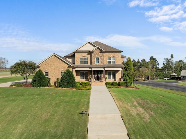 view of front of house with a porch, brick siding, and a front lawn