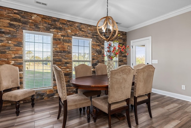 dining space featuring plenty of natural light, ornamental molding, an inviting chandelier, and visible vents