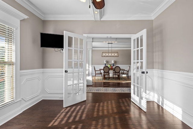interior space with french doors, ornamental molding, and a wainscoted wall