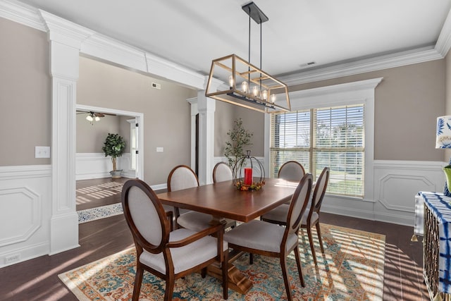 dining area with crown molding, a wainscoted wall, dark wood-style flooring, and ornate columns