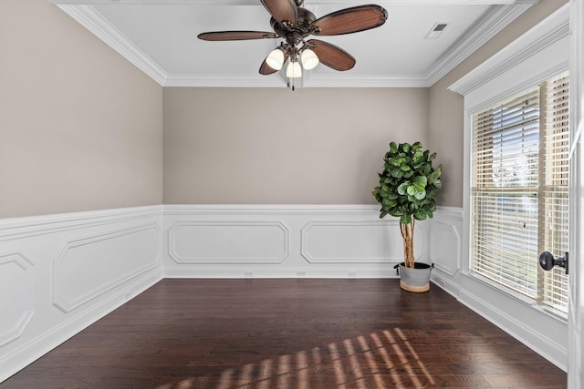 spare room featuring crown molding, ceiling fan, visible vents, and wainscoting
