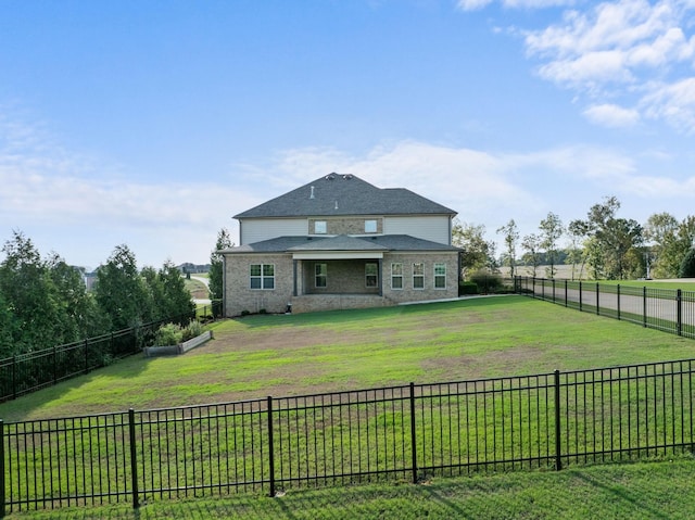 back of property featuring a fenced backyard, a lawn, and stone siding