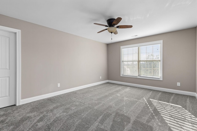 carpeted empty room featuring a ceiling fan and baseboards