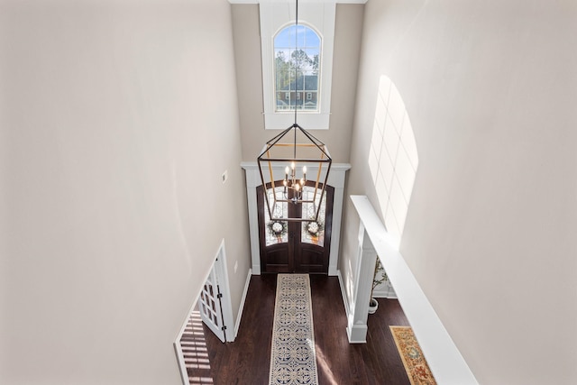 entryway with an inviting chandelier, baseboards, a high ceiling, and wood finished floors