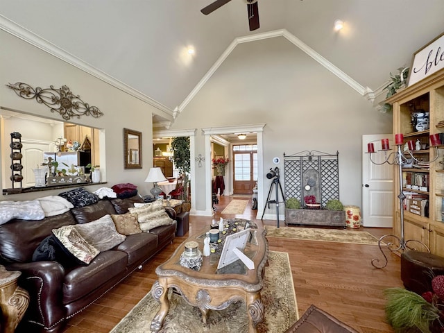 living room featuring hardwood / wood-style floors, high vaulted ceiling, ceiling fan, and ornamental molding